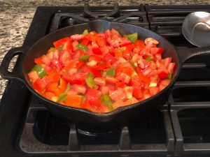 Shakshouka vegetables with tomatoes in skillet